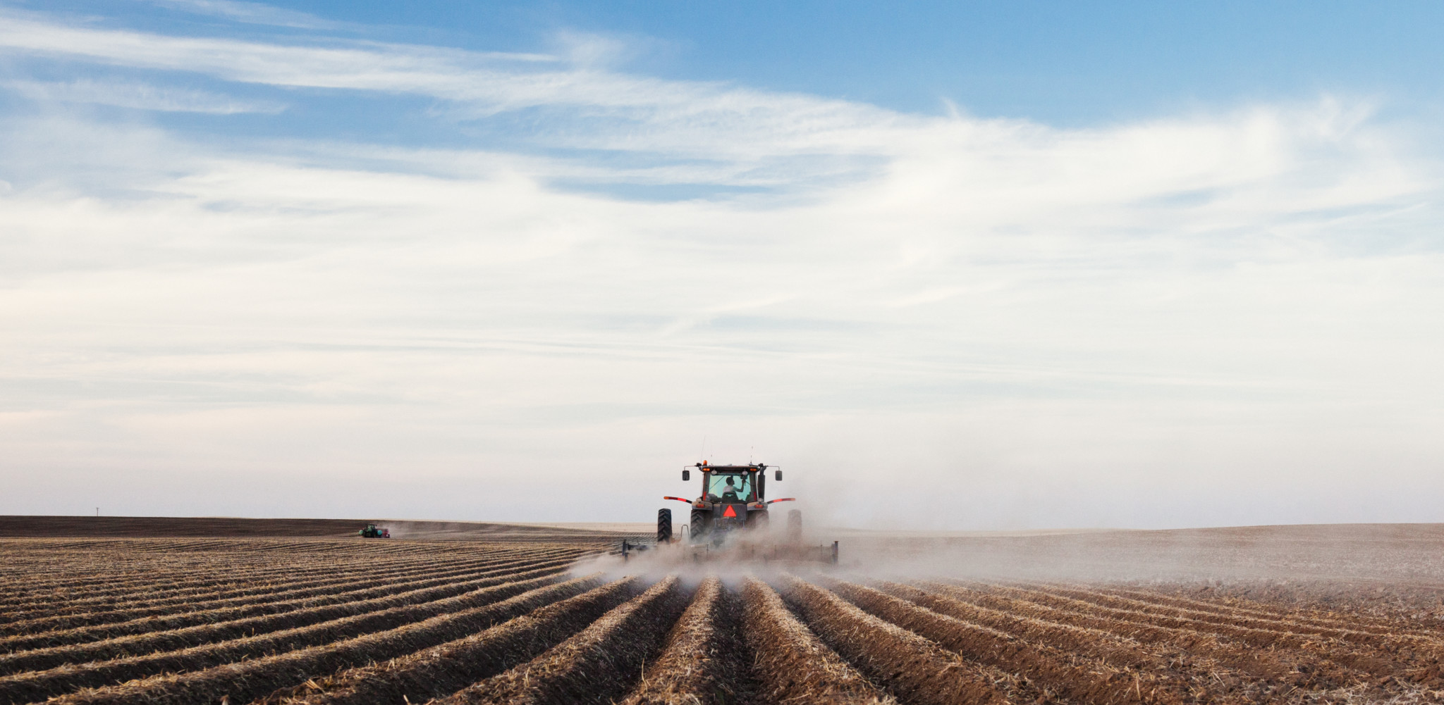A tractor planting a potato crop on the prairies.